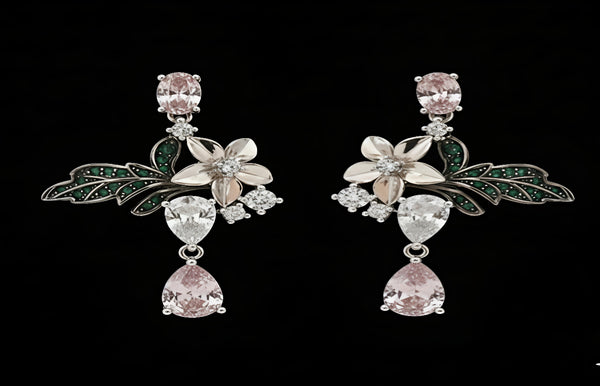 Pair of floral earrings with pink gemstones on a black background