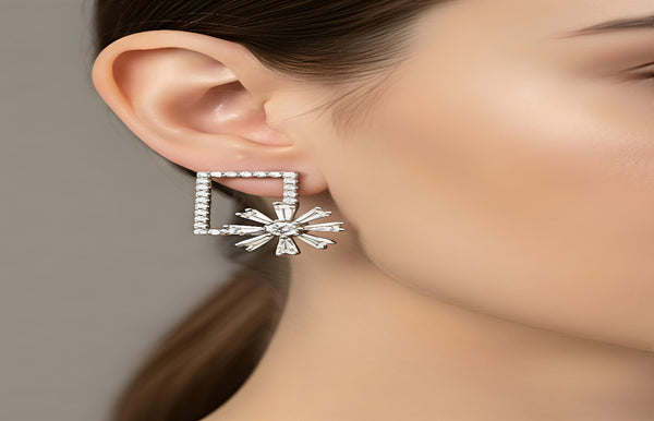 Silver square-shaped earring worn by a person with a neutral background