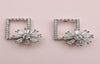 Pair of silver square-framed earrings with starburst design on a pink background