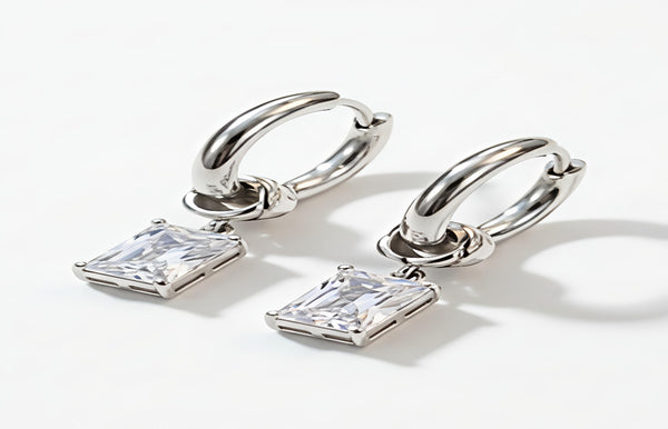 Silver hoop earrings with square-cut gemstones on a white background