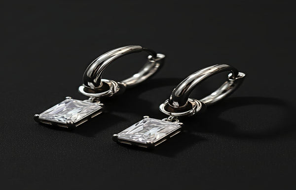 Silver hoop earrings with rectangular gemstones on a black background