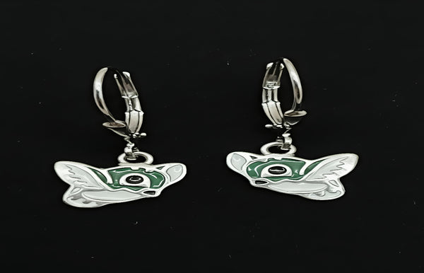 Butterfly-shaped earrings with green center on a black background