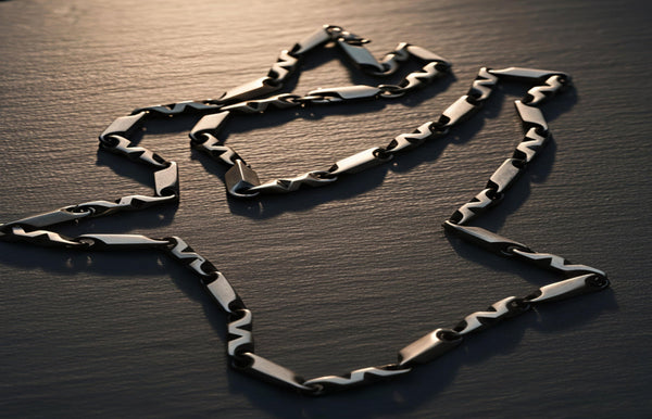 Silver chain on a dark textured surface