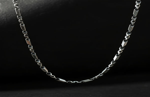 Silver chain necklace on a black background
