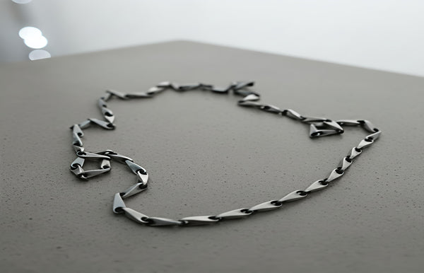 Silver chain bracelet on a reflective surface