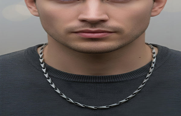 Man wearing a chain necklace against a neutral background