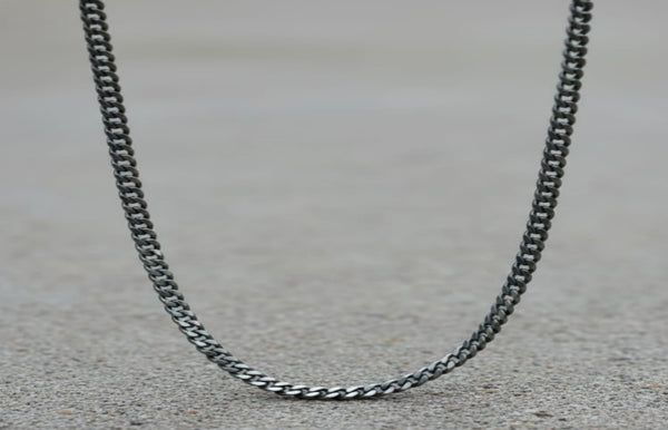 Silver chain necklace on a textured surface