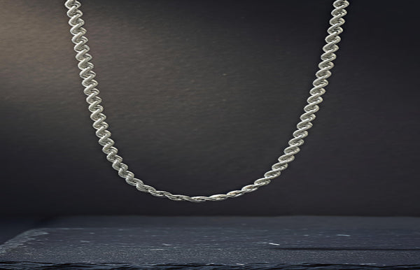 Silver rope chain necklace on a dark background