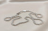Silver chain necklace on a light beige background