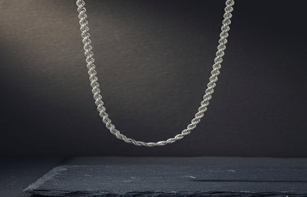 Silver rope chain necklace on a dark background