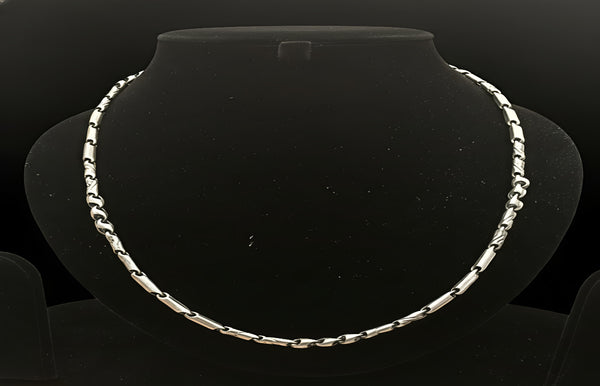 Silver necklace on a black mannequin bust