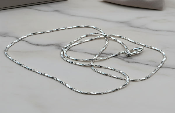 Silver chain necklace on a marble surface